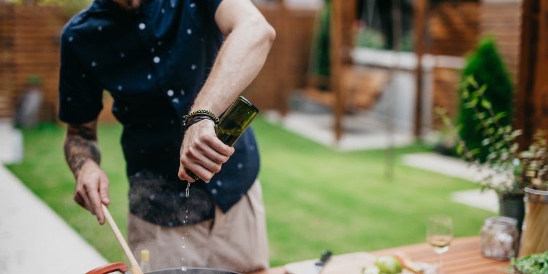 chef-putting-wine-in-a-dish-picture-id1045439218-1