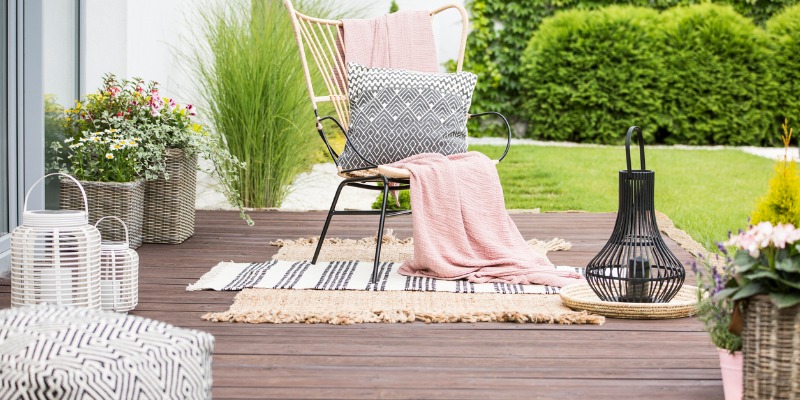 real-photo-of-a-white-pillow-and-pink-blanket-on-a-rattan-chair-in-picture-id1043486596-1